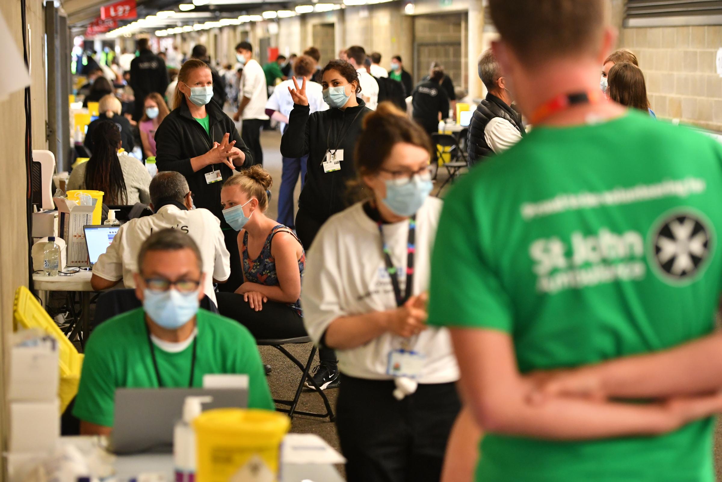 People queue up to receive a coronavirus vaccination at Twickenham Stadium